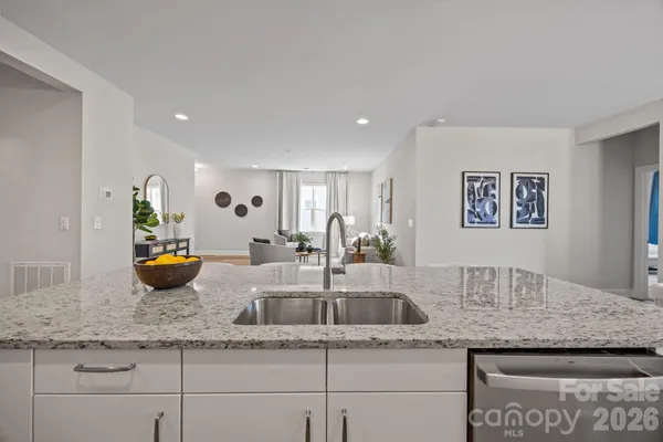 a kitchen with granite countertop white cabinets and a stove top oven