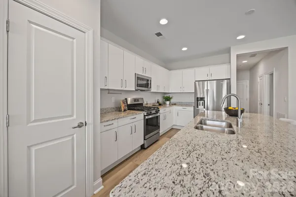 a kitchen with white cabinets and stainless steel appliances