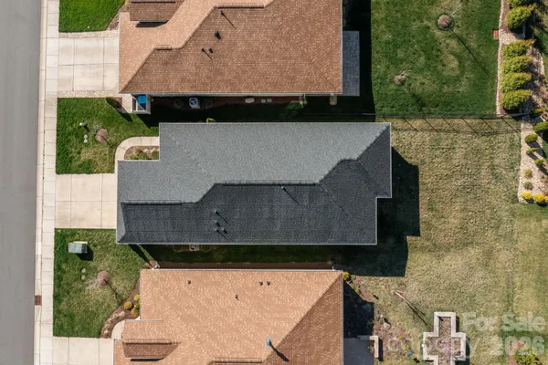 an aerial view of a house with a garden and lake view