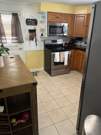 a kitchen with stainless steel appliances kitchen island a stove a sink and a refrigerator