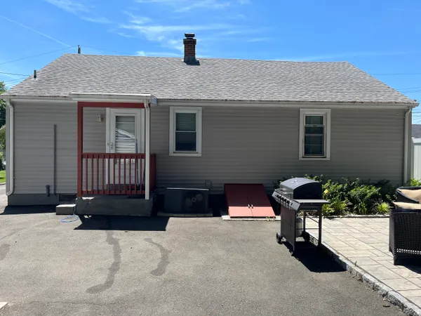a view of a house with a yard and sitting area