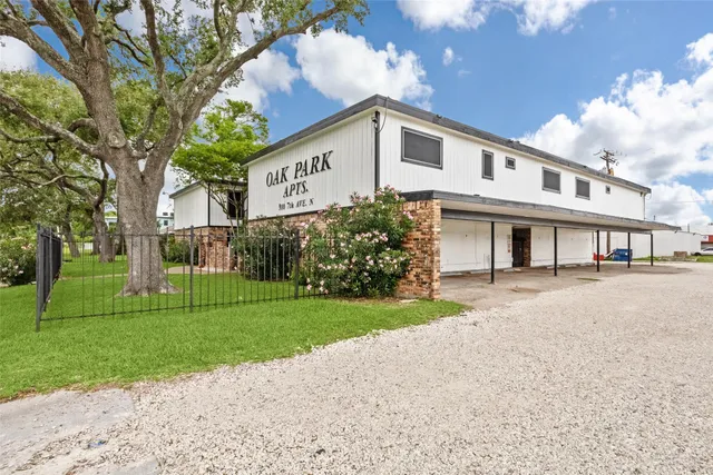 a view of a house with a yard and large trees