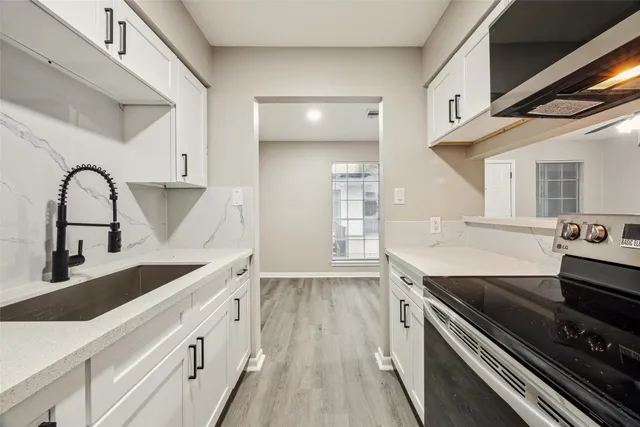 a kitchen with stainless steel appliances granite countertop a sink and cabinets