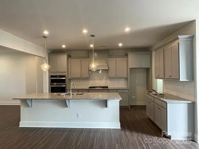 a kitchen with kitchen island stainless steel appliances a sink and refrigerator