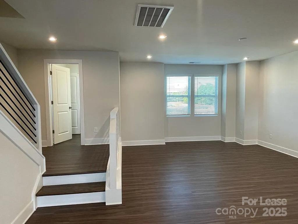 3121 Treble Court Charlotte, NC 28262 - Photo 6 of 14 an empty room with wooden floor and staircase