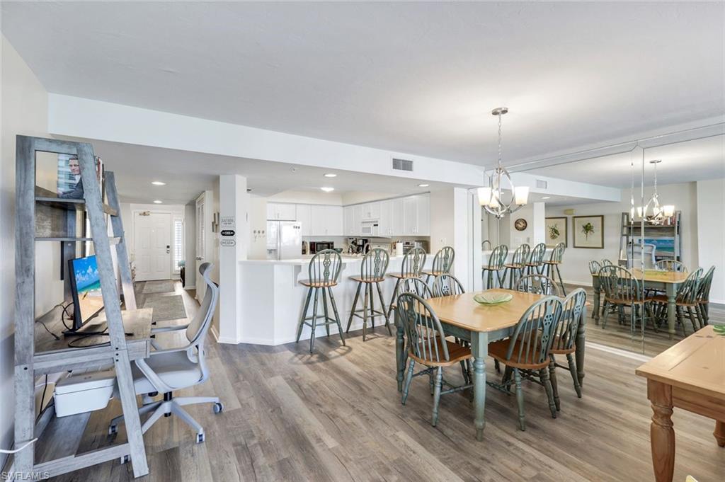 21 Bluebill Avenue, Unit B905 Naples, FL 34108 - Photo 14 of 35 a dining room with furniture and wooden floor