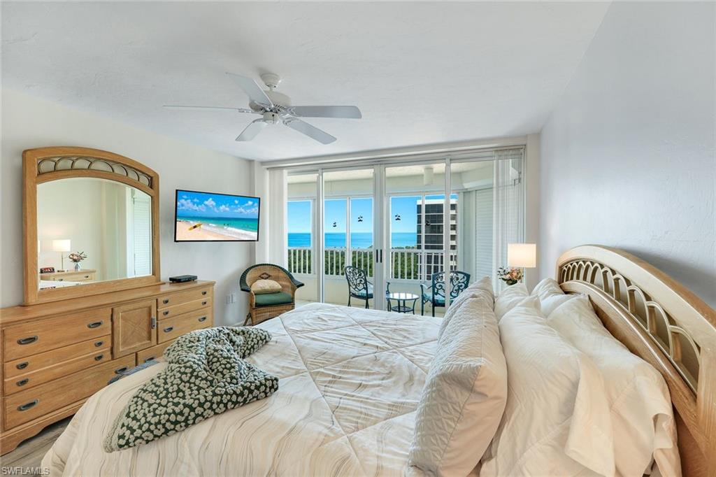 21 Bluebill Avenue, Unit B905 Naples, FL 34108 - Photo 16 of 35 a bedroom with a bed a large window with the dresser in front of it