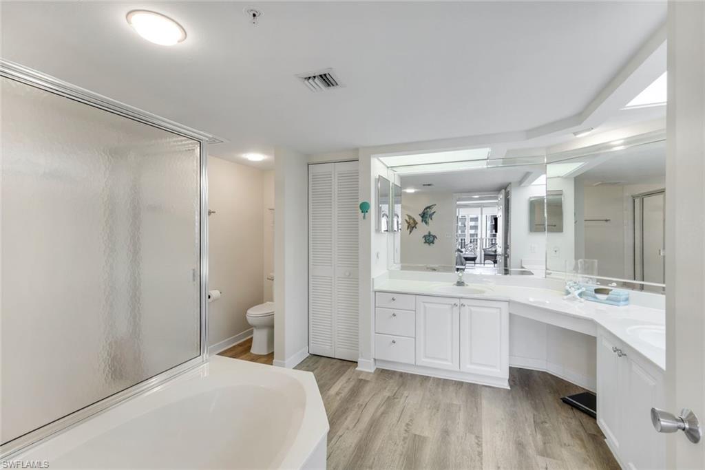 21 Bluebill Avenue, Unit B905 Naples, FL 34108 - Photo 19 of 35 a spacious bathroom with a shower a sink and a mirror