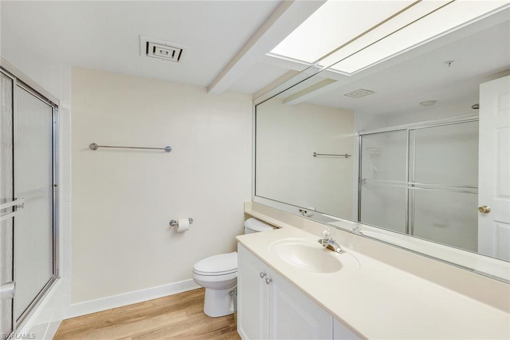 21 Bluebill Avenue, Unit B905 Naples, FL 34108 - Photo 22 of 35 a bathroom with a sink and mirror with toilet