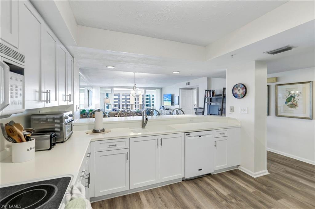 21 Bluebill Avenue, Unit B905 Naples, FL 34108 - Photo 10 of 35 a large white kitchen with a sink a window and stainless steel appliances