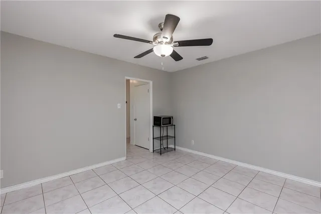 an empty room with closet and fan