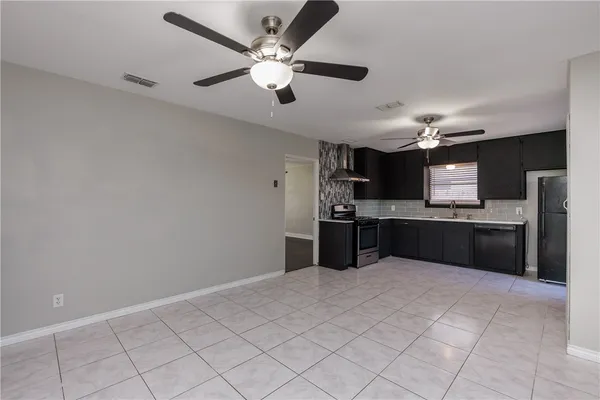 a large kitchen with a sink and stainless steel appliances