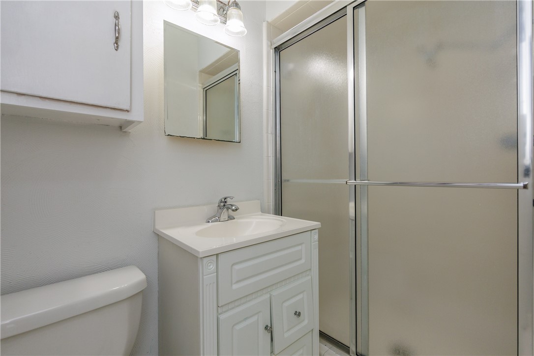 4122 Barnes Street Corpus Christi, TX 78411 - Photo 20 of 39 a bathroom with a toilet sink vanity and mirror