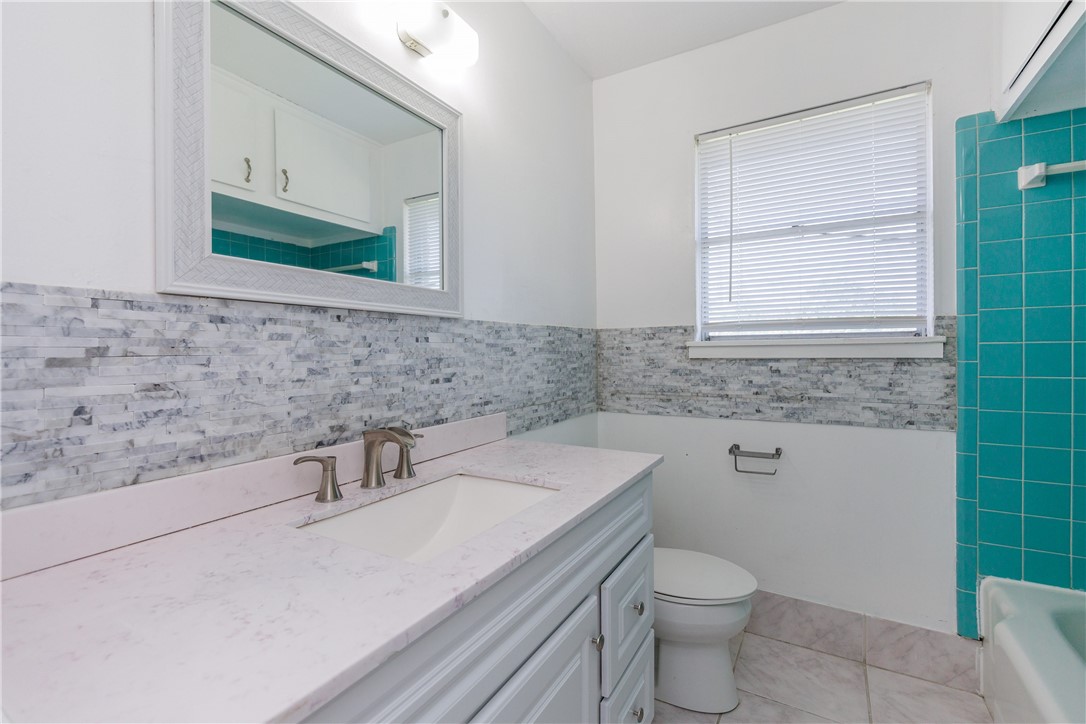 4122 Barnes Street Corpus Christi, TX 78411 - Photo 27 of 39 a bathroom with a sink a toilet and a mirror