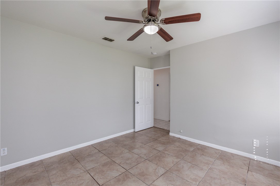 4122 Barnes Street Corpus Christi, TX 78411 - Photo 28 of 39 an empty room with a ceiling fan and carpet