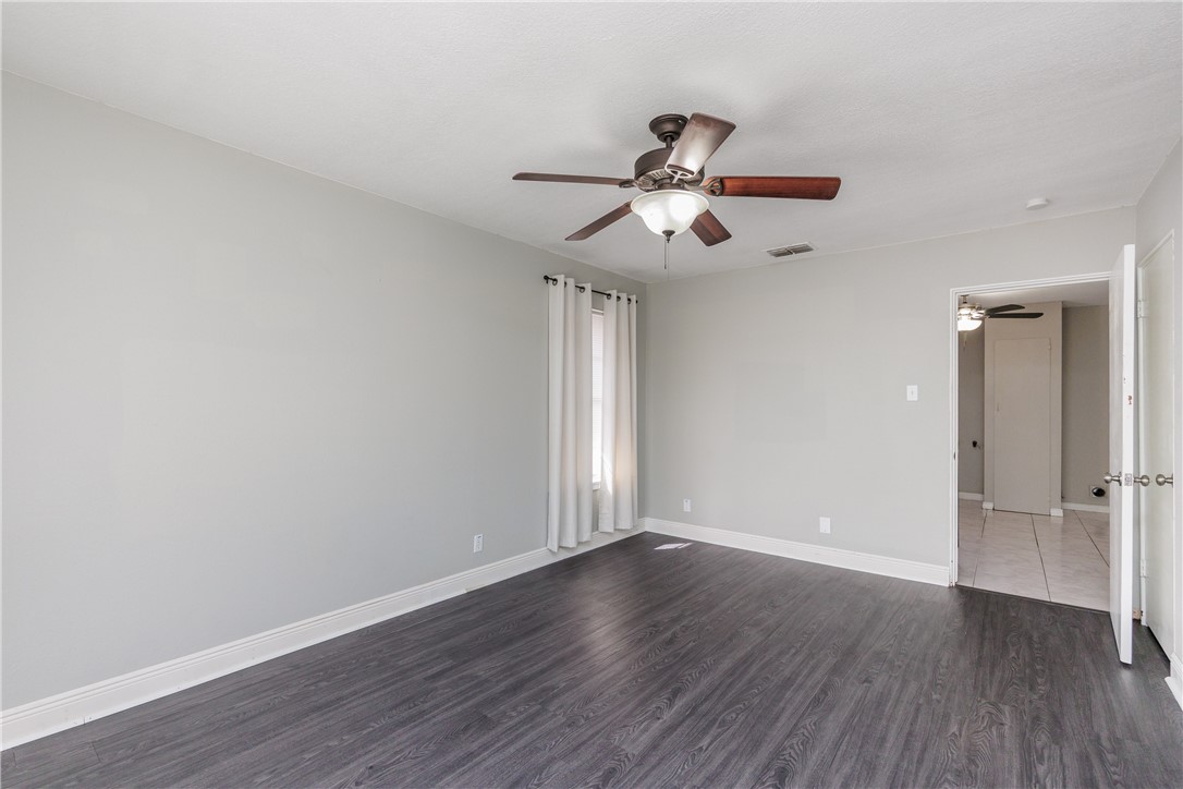 4122 Barnes Street Corpus Christi, TX 78411 - Photo 5 of 39 an empty room with wooden floor fan and windows