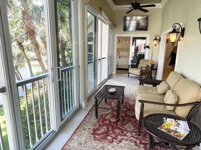 a living room with furniture a rug and a floor to ceiling window