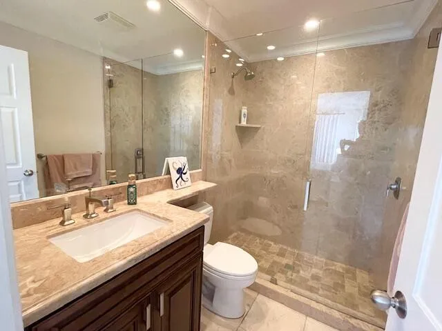 a bathroom with a granite countertop sink a toilet a mirror and shower