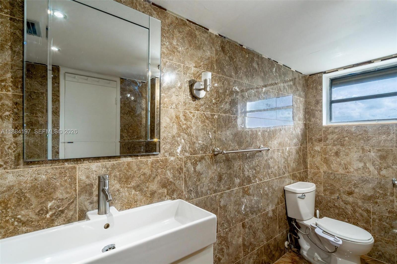 1750 Northeast 191st Street, Unit 7001 Miami, FL 33179 - Photo 14 of 30 a bathroom with a sink a toilet and shower