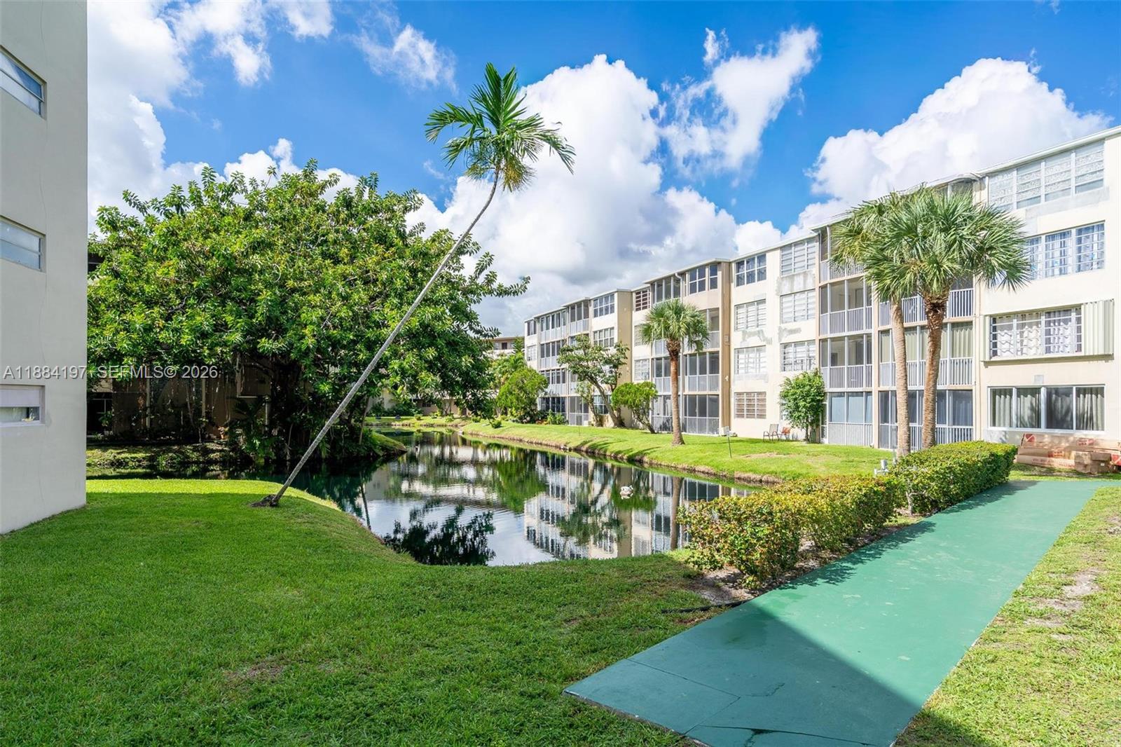 1750 Northeast 191st Street, Unit 7001 Miami, FL 33179 - Photo 24 of 30 a view of a house with a big yard and potted plants