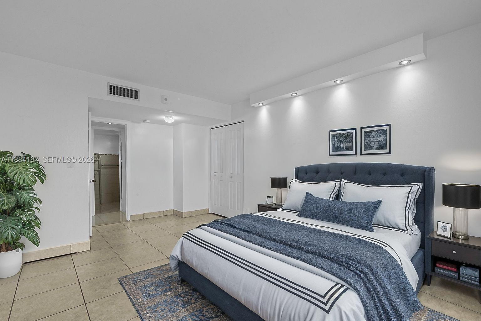 1750 Northeast 191st Street, Unit 7001 Miami, FL 33179 - Photo 4 of 30 a spacious bedroom with a bed and a potted plant