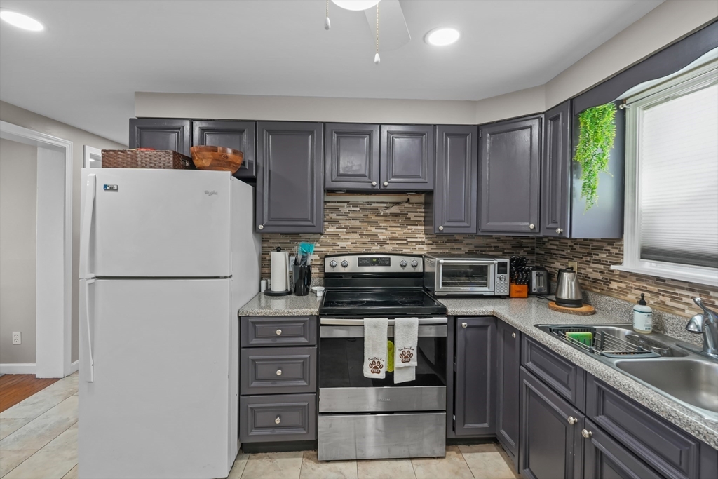 172 Perry Avenue, Unit 1A Worcester, MA 01610 - Photo 17 of 26 a kitchen with refrigerator a stove a sink and a window