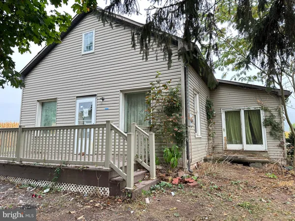 a view of a house with a yard and large tree