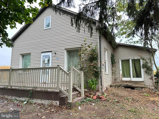 a view of a house with a yard and large tree