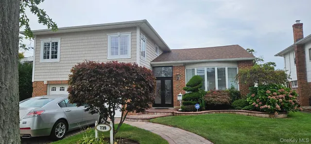 a front view of a house with a garden and plants