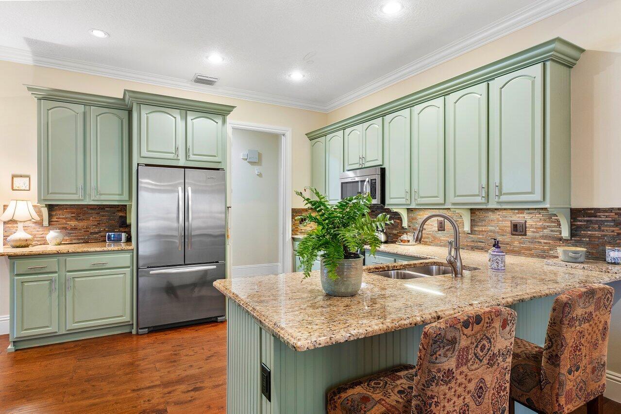 142 Mangrove Bay Way Jupiter, FL 33477 - Photo 7 of 17 a kitchen with stainless steel appliances granite countertop a sink and a refrigerator