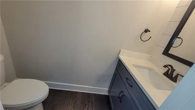 a bathroom with a granite countertop sink toilet and a mirror