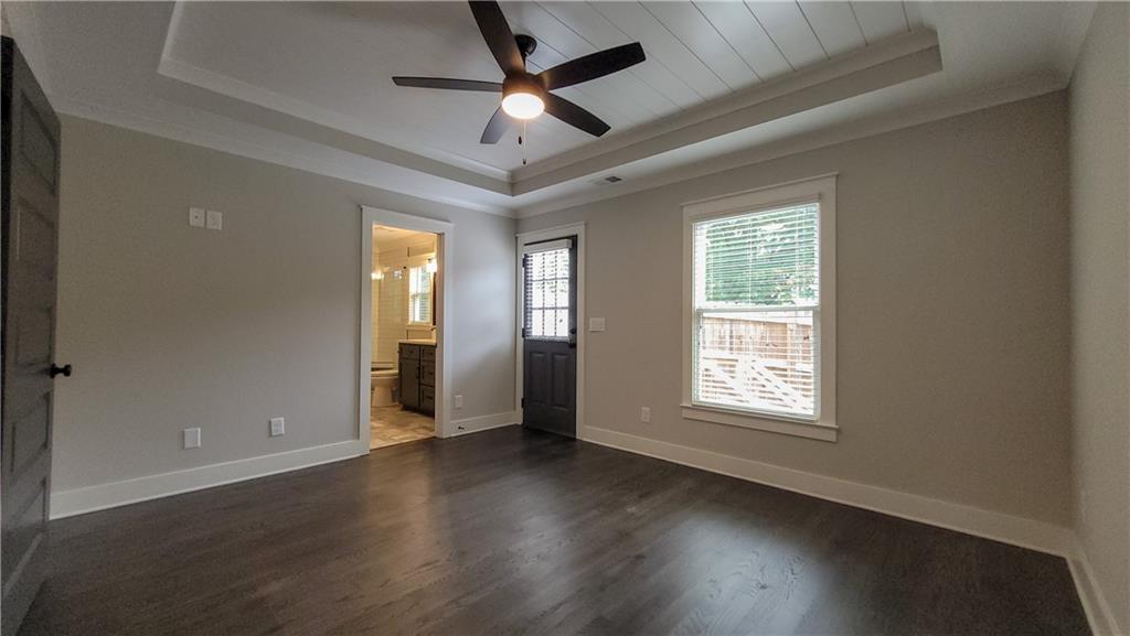 110 Strippling Street Ball Ground, GA 30107 - Photo 8 of 13 an empty room with wooden floor chandelier fan and windows
