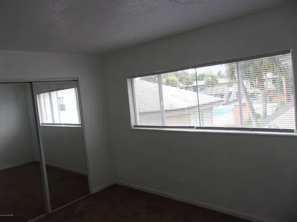 an empty room with windows and closet