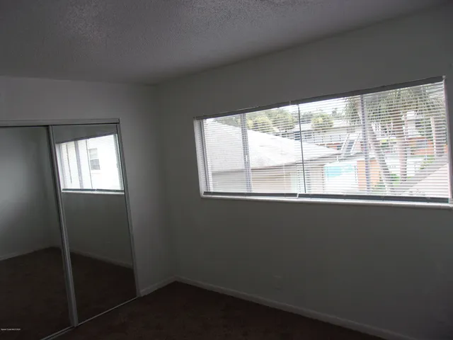 an empty room with windows and closet