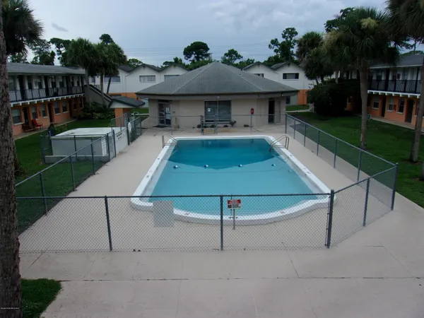 an aerial view of a house with swimming pool and furniture