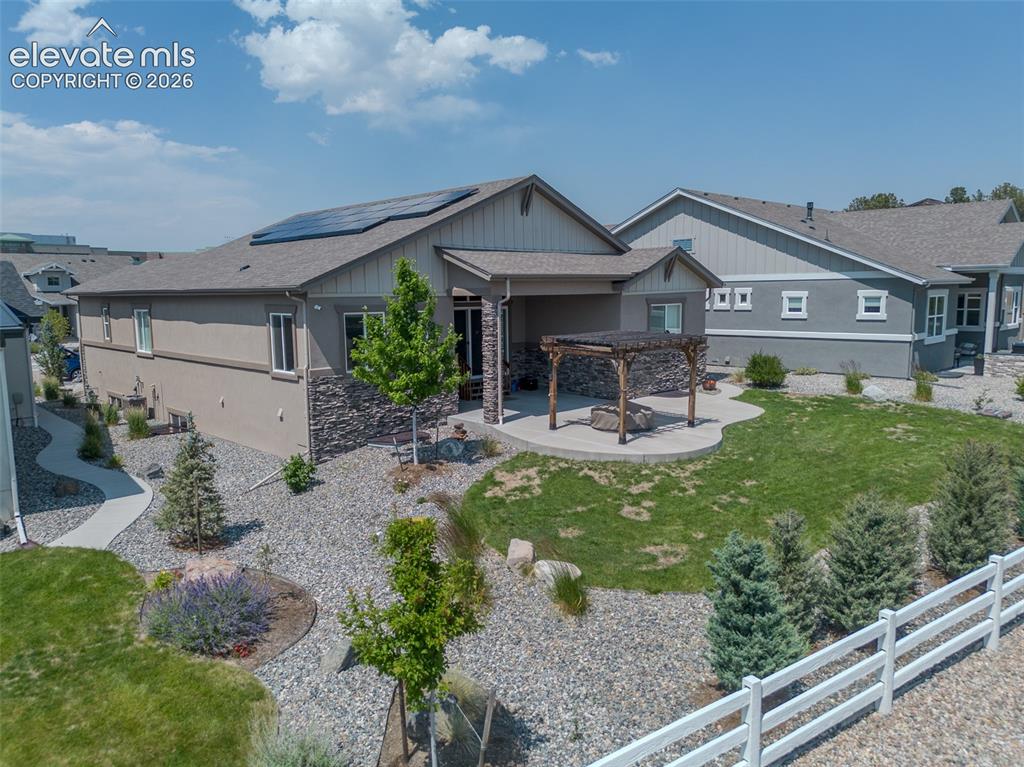 1061 Native Dancer Terrace Colorado Springs, CO 80921 - Photo 50 of 50 Rear exterior featuring a covered patio, stone veneer accents, and a pergola with a fire pit area