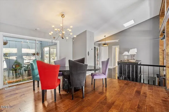 a dining room with furniture a chandelier and wooden floor