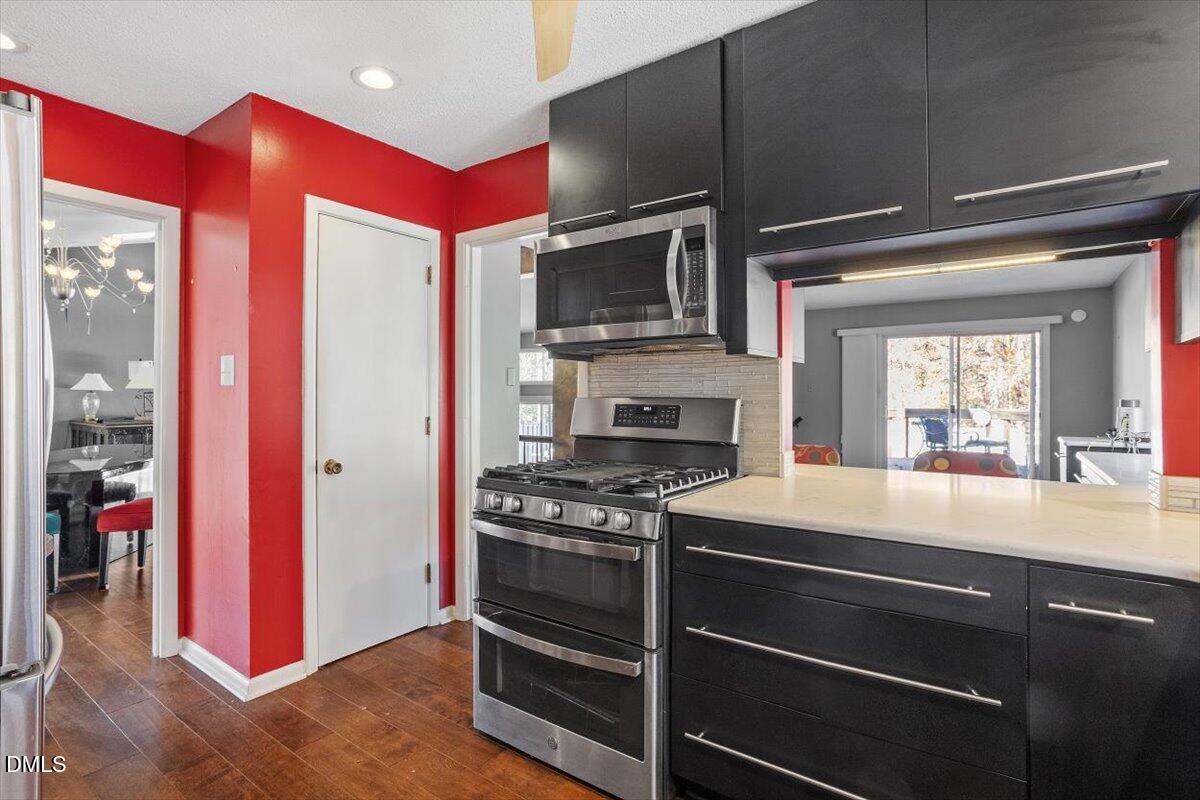 4501 Wingate Drive Raleigh, NC 27609 - Photo 10 of 36 a kitchen with stainless steel appliances a stove and a refrigerator