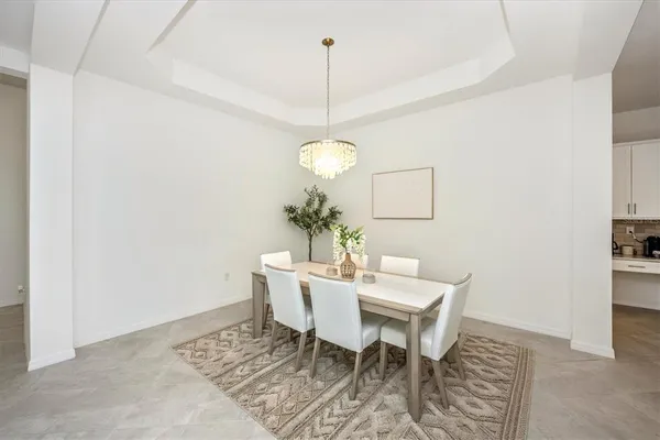 a living room with furniture a chandelier and a potted plant