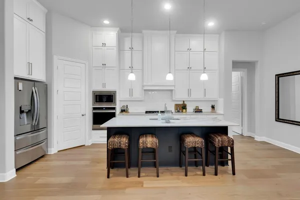a large kitchen with cabinets and stainless steel appliances