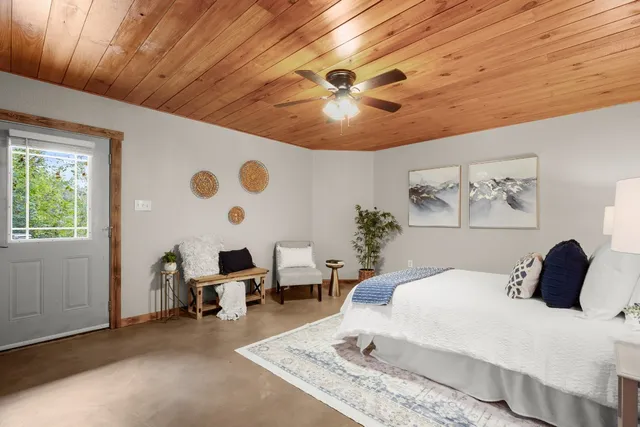 a spacious bedroom with a bed and a chandelier