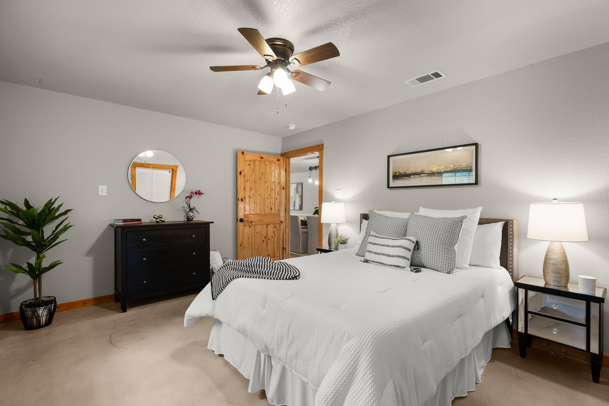 235 Smith Creek Road Wimberley, TX 78676 - Photo 13 of 40 a bedroom with a large bed and a chandelier