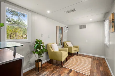 a view of a livingroom with furniture wooden floor and a large window