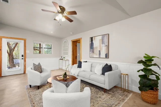 a living room with furniture ceiling fan and a window