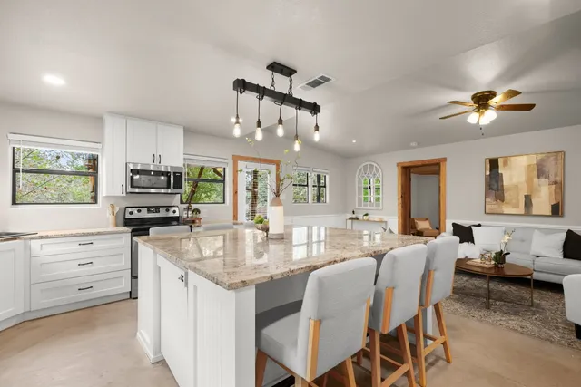 a kitchen with granite countertop lots of counter space dining table and stainless steel appliances