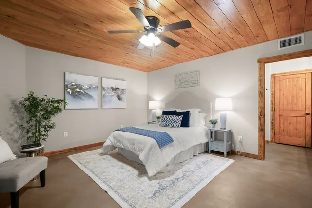 a bedroom with a large bed and a chandelier