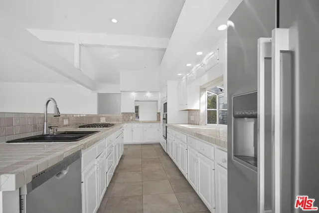 a large kitchen with kitchen island a sink stainless steel appliances and cabinets