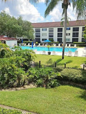 a view of a house with swimming pool and a yard
