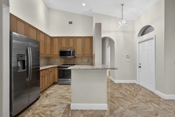 a kitchen with stainless steel appliances granite countertop a refrigerator stove and microwave