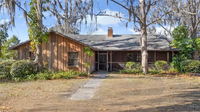 a front view of a house with a yard and potted plants